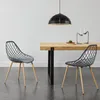 Two gray chairs are placed in front of a wooden dining table, with a black pendant light hanging above. Náhľad obrázku produktu