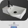 A white ceramic sink with a black faucet against a dark gray background. Produktbild-Vorschau