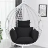 A white hanging chair with black cushions is shown indoors, near a window with sheer curtains and a framed picture on the wall. Produktbild-Vorschau