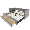 A grey upholstered bed frame with wooden slats and two open drawers underneath, shown against a white background. Náhled obrázku produktu