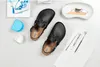 A pair of black Birkenstock clogs are laid out on a white surface with dental tools and supplies. Anteprima dell’immagine prodotto