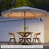 An outdoor patio scene at dusk with a table and chairs set up under a large umbrella. Produktbild-Vorschau