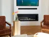 A modern living room with a fireplace and chairs. Anteprima dell’immagine prodotto