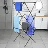 A black metal drying rack with several towels hanging on it, placed in a modern bathroom setting. Náhľad obrázku produktu