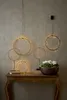 A collection of LED ring lights and a basket of flowers are displayed on a wooden console table against a textured wall. Produktbild-Vorschau