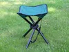 A green folding stool sits on a grassy lawn. Voir les images du produit