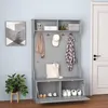 A grey hall tree with a bench and shoe storage, placed in a room with a light blue wall and a white door. Náhled obrázku produktu