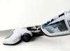 A close-up shot of a white and black cordless vacuum cleaner with a transparent dustbin, positioned on a white surface. Náhled obrázku produktu