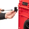 A person is using a screwdriver to attach a black connector to a red modular storage system. Anteprima dell’immagine prodotto