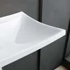 A close-up view of a white ceramic sink with a dark gray wall in the background. Produktbild-Vorschau