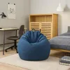 A blue bean bag chair is placed on a rug in a room with a desk, chair, and cabinet. Voir les images du produit