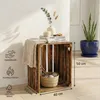 A wooden crate used as a side table, decorated with books, a candle, and a plant in a blue pot. Náhled obrázku produktu