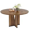 A round wooden dining table with a floral arrangement and a small tray of snacks. Voir les images du produit