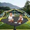 Two young children sitting on a black net attached to a colorful climbing frame in an outdoor setting with a lake and mountains in the background. Anteprima dell’immagine prodotto