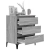 A gray wooden dresser with three drawers partially open, displayed against a white background. Decorative items are on top of the dresser. Podgląd zdjęcia produktu