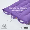 A close-up of a purple tufted cushion with straps and buttons, showing details of its construction and care instructions. Náhled obrázku produktu