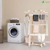 A laundry room scene with a washing machine and a drying rack filled with clothes. Produktbild-Vorschau