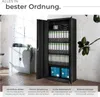 An open black metal filing cabinet filled with binders, next to a smaller gray cabinet. The scene is set in a bright, modern office or storage space. Produktbild-Vorschau