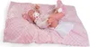 A baby doll lying on a pink blanket. Anteprima dell’immagine prodotto