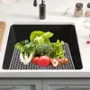 A collection of fresh vegetables and mushrooms are arranged on a gray hexagonal mat inside a kitchen sink. Podgląd zdjęcia produktu
