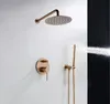 A rose gold shower set mounted on a white wall, with water spraying from the handheld showerhead. Náhled obrázku produktu