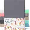 A stack of folded jersey fitted sheets in various colors, with a large gray sheet prominently displayed in the center. Produktbild-Vorschau