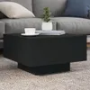 A black coffee table with a cup and a plant on it, placed on a rug in front of a sofa. Produktbild-Vorschau
