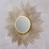A sunburst mirror on a gray concrete background. Produktbild-Vorschau