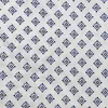 A close-up of a white fabric with a repeating pattern of small blue and black diamond shapes. Produktbild-Vorschau
