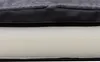 A close-up view of the layered construction of a dog bed, showing the outer fabric and the foam interior. Produktbild-Vorschau
