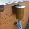 A close-up view of an in-wall skimmer and hose attached to the side of a wooden above-ground swimming pool. Produktbild-Vorschau