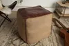 A pouf is placed on a rug in a room, with a chair and a guitar visible. Produktbild-Vorschau