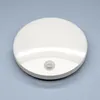 A white, round LED outdoor light with a motion sensor is shown on a light gray background. Produktbild-Vorschau