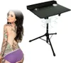 A tattooed woman is shown next to a portable tattoo workstation. Náhled obrázku produktu