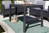 An outdoor patio setting with a table and chairs. Anteprima dell’immagine prodotto