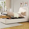 A bedroom scene with a bed that has its storage compartment open, revealing items inside. A window with curtains is visible in the background. Produktbild-Vorschau