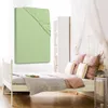 A light green fitted sheet is displayed prominently in the foreground, with a bed and bedroom setting in the background. Produktbild-Vorschau