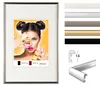 A framed picture of a woman with macarons, surrounded by color swatches and a diagram of a frame profile. Produktbild-Vorschau