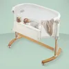A baby sleeping in a bedside bassinet. Produktbild-Vorschau