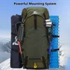 A green backpack with various camping accessories attached, set against a snowy mountain backdrop. Náhľad obrázku produktu