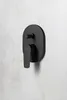 A black matte shower faucet is mounted on a textured gray wall. Náhled obrázku produktu