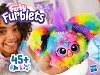 A young girl is holding a colorful Furby toy. Anteprima dell’immagine prodotto