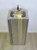 A stainless steel sink with a cabinet underneath, set against a plain wall and wooden floor. Podgląd zdjęcia produktu