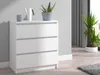 A white chest of drawers with three drawers is shown in a room with a plant and a window in the background. Produktbild-Vorschau
