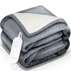 A folded gray electric blanket with a white sherpa lining and a controller.