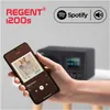 A hand holding a smartphone displaying a music app, with a radio in the background. Produktbild-Vorschau