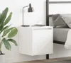 A white wall-mounted nightstand with a lamp, a cup, and books on top, next to a bed with gray bedding. Náhled obrázku produktu