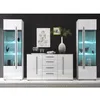 A modern white high-gloss living room wall unit with two display cabinets and a sideboard against a black wall. Produktbild-Vorschau