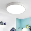 A modern, round LED ceiling light is shown mounted on a white ceiling in a room with light blue walls. Produktbild-Vorschau