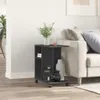 A black side table with wheels is placed next to a sofa in a living room. Podgląd zdjęcia produktu